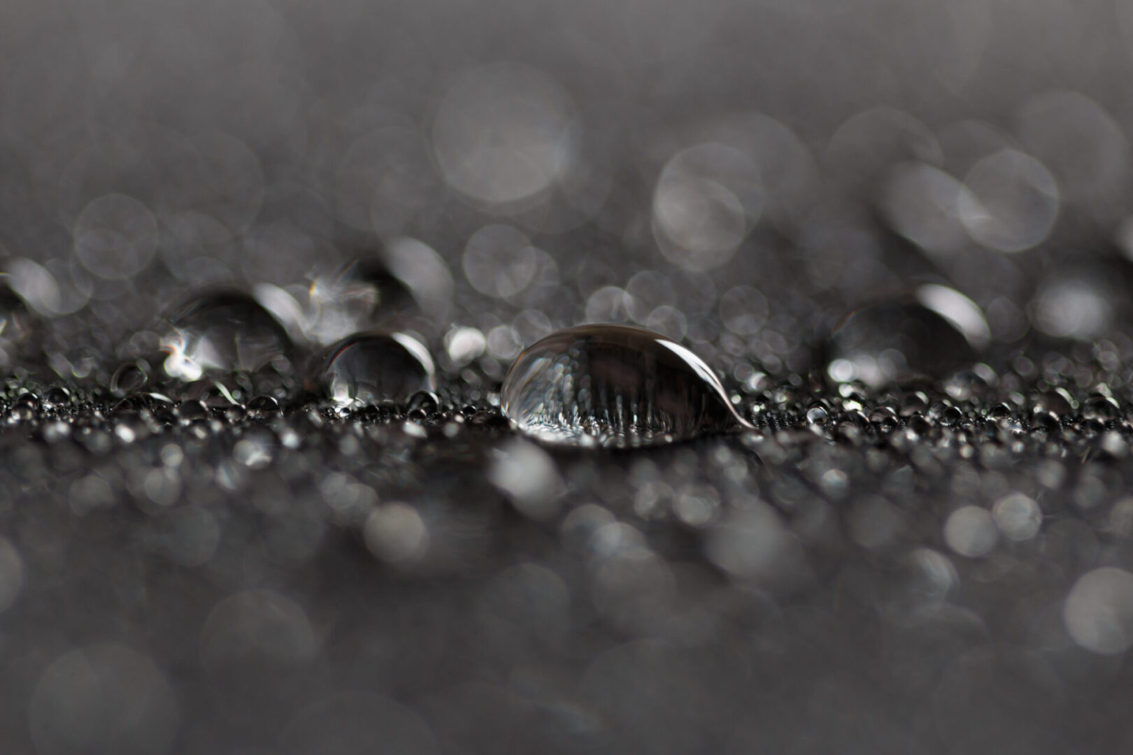 Rain water droplets on a black waterproof fabric